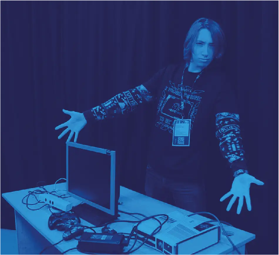 Uczestnik hackathonu BITEhack prezentujący swoje stanowisko pracy z monitorem i elektroniką.